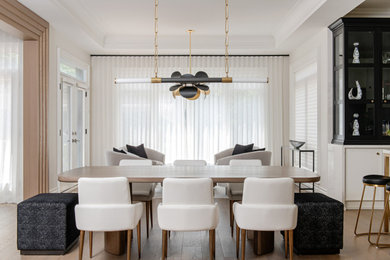 Mid-sized trendy light wood floor and tray ceiling kitchen/dining room combo photo in Toronto with white walls