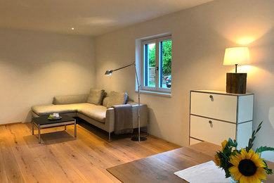 Mittelgroßes, Repräsentatives, Offenes Modernes Wohnzimmer mit weißer Wandfarbe, gebeiztem Holzboden, Eckkamin, TV-Wand und braunem Boden in München