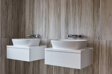 Photo of a small contemporary bathroom in London with a one-piece toilet, beige walls and a wall-mounted sink.