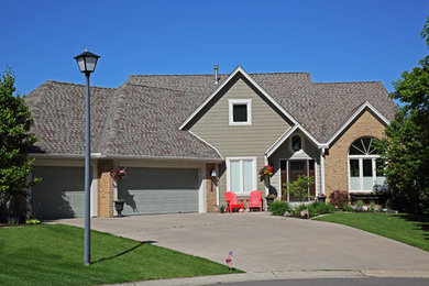 This is an example of a mid-sized arts and crafts two-storey brown house exterior in Minneapolis with mixed siding, a gable roof and a shingle roof.