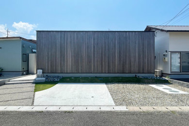 Imagen de fachada de casa marrón y negra moderna de tamaño medio de una planta con revestimiento de madera, tejado de un solo tendido, tejado de metal y panel y listón