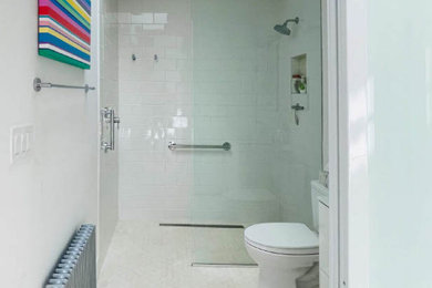 Mid-sized transitional kids' white tile and ceramic tile mosaic tile floor, beige floor and single-sink bathroom photo in DC Metro with flat-panel cabinets, white cabinets, a one-piece toilet, white walls, a wall-mount sink, white countertops, a niche and a floating vanity