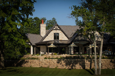 Example of a huge mountain style brown one-story stone house exterior design in Detroit with a hip roof and a shingle roof