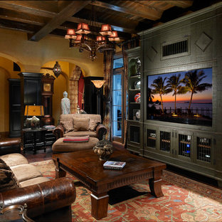 Mittelgroßes, Abgetrenntes Mediterranes Wohnzimmer ohne Kamin mit gelber Wandfarbe, dunklem Holzboden, Wand-TV und gelbem Boden in Orlando