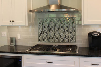 Inspiration for a large modern l-shaped kitchen remodel in Other with a farmhouse sink, gray backsplash, subway tile backsplash, stainless steel appliances and an island