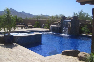 Inspiration for a large transitional backyard brick and custom-shaped hot tub remodel in Phoenix
