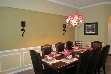 Large elegant carpeted enclosed dining room photo in Houston with yellow walls