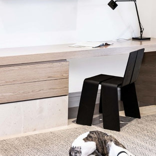 パースの中サイズのモダンスタイルのおしゃれな書斎 (白い壁、ライムストーンの床、標準型暖炉、造り付け机) の写真