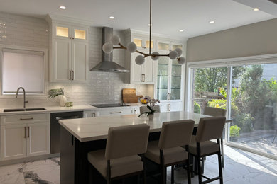 Inspiration for a mid-sized transitional porcelain tile and multicolored floor kitchen remodel in Toronto with an undermount sink, raised-panel cabinets, white cabinets, quartzite countertops, white backsplash, subway tile backsplash, stainless steel appliances and white countertops