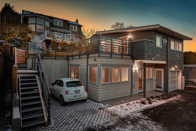 Photo of a small modern two-storey beige exterior in Vancouver with wood siding.