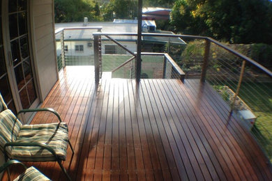 Design ideas for a mid-sized modern balcony in Cairns with a roof extension.