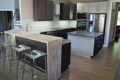 Example of a large minimalist eat-in kitchen design in Raleigh with flat-panel cabinets, concrete countertops, white backsplash, subway tile backsplash, stainless steel appliances, an island and gray countertops
