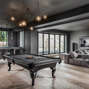 Modelo de sótano con puerta mediterráneo con paredes negras, suelo de madera clara y suelo beige