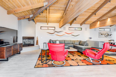 Trendy open concept gray floor, exposed beam and wood ceiling living room photo in Santa Barbara with white walls, a corner fireplace, a tile fireplace and a tv stand