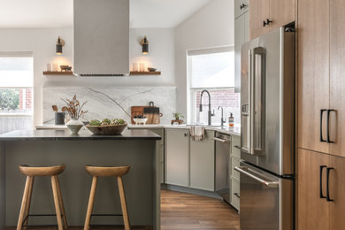 Eat-in kitchen - contemporary medium tone wood floor and brown floor eat-in kitchen idea in Austin with an undermount sink, quartz countertops, quartz backsplash, stainless steel appliances and an island