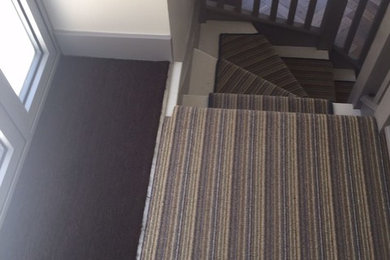 This is an example of a small contemporary hallway in London with white walls, carpet, a double front door and white floors.