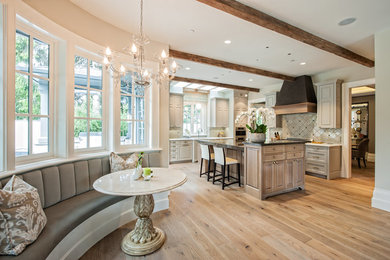 Inspiration for a large timeless l-shaped medium tone wood floor eat-in kitchen remodel in Vancouver with an undermount sink, raised-panel cabinets, gray cabinets, granite countertops, gray backsplash, ceramic backsplash, stainless steel appliances and an island