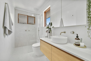 This is an example of a contemporary bathroom in Perth with flat-panel cabinets, light wood cabinets, a curbless shower, white tile, mosaic tile, white walls, a vessel sink, white floor, an open shower, white benchtops, a single vanity and a floating vanity.