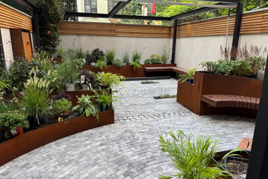 Design ideas for a mid-sized modern backyard stone fence landscaping in New York with a pergola.