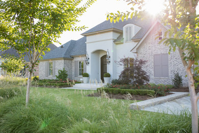 Mid-sized traditional white one-story mixed siding house exterior idea in New Orleans with a hip roof and a shingle roof