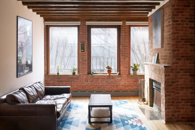 Imagen de salón abierto moderno de tamaño medio con suelo de madera clara, todas las chimeneas, marco de chimenea de ladrillo, vigas vistas y ladrillo