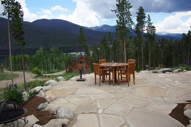 Inspiration for a mid-sized rustic backyard stone patio remodel in Denver