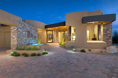 Photo of a large contemporary one-storey beige house exterior in Phoenix with mixed siding and a flat roof.
