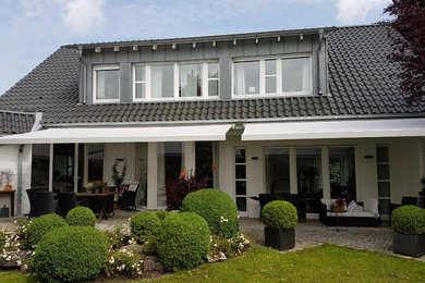 This is an example of a mid-sized contemporary deck in Dortmund with an awning.
