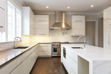 Large contemporary u-shaped eat-in kitchen in New York with an undermount sink, flat-panel cabinets, white cabinets, white splashback, panelled appliances, dark hardwood floors, with island, brown floor, solid surface benchtops and stone tile splashback.