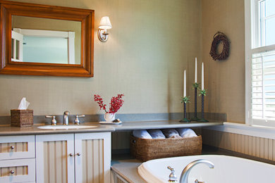 Mid-sized elegant master drop-in bathtub photo in New York with beaded inset cabinets, beige cabinets, beige walls, an undermount sink, quartz countertops and gray countertops