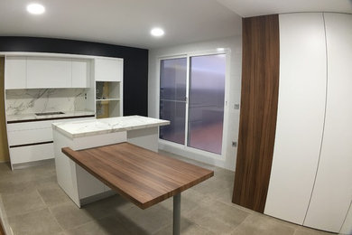 Large modern single-wall separate kitchen in Other with an undermount sink, flat-panel cabinets, white cabinets, quartz benchtops, white splashback, limestone splashback, stainless steel appliances, porcelain floors, with island and grey floor.