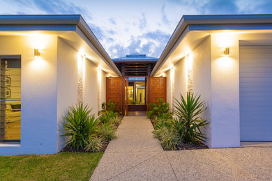 Inspiration for a modern entryway in Sunshine Coast with white walls, a pivot front door and a medium wood front door.