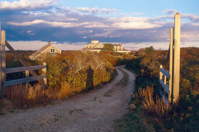 Example of a beach style gray two-story wood exterior home design in Boston with a shingle roof
