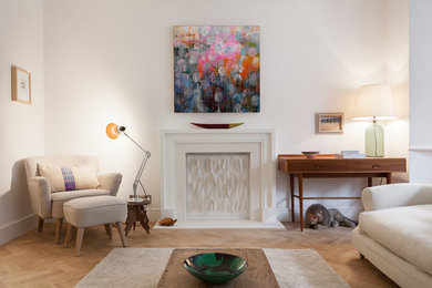 This is an example of a medium sized bohemian open plan living room in Surrey with white walls, medium hardwood flooring and brown floors.