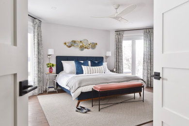 Large transitional master brown floor bedroom photo in Toronto with gray walls