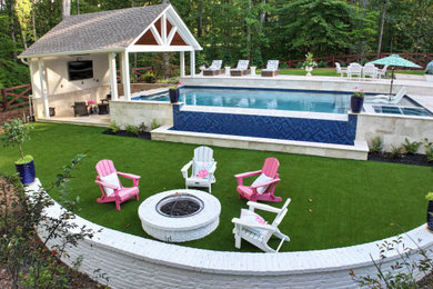 Mid-sized trendy backyard stone and rectangular infinity pool photo in Atlanta
