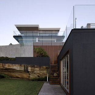 Foto på ett funkis svart hus, med två våningar och blandad fasad