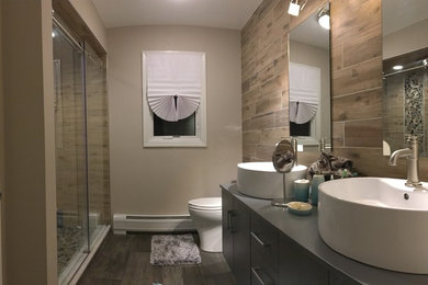 Bathroom - large contemporary kids' brown tile and porcelain tile porcelain tile and gray floor bathroom idea in Newark with flat-panel cabinets, gray cabinets, a one-piece toilet, brown walls, a vessel sink and wood countertops