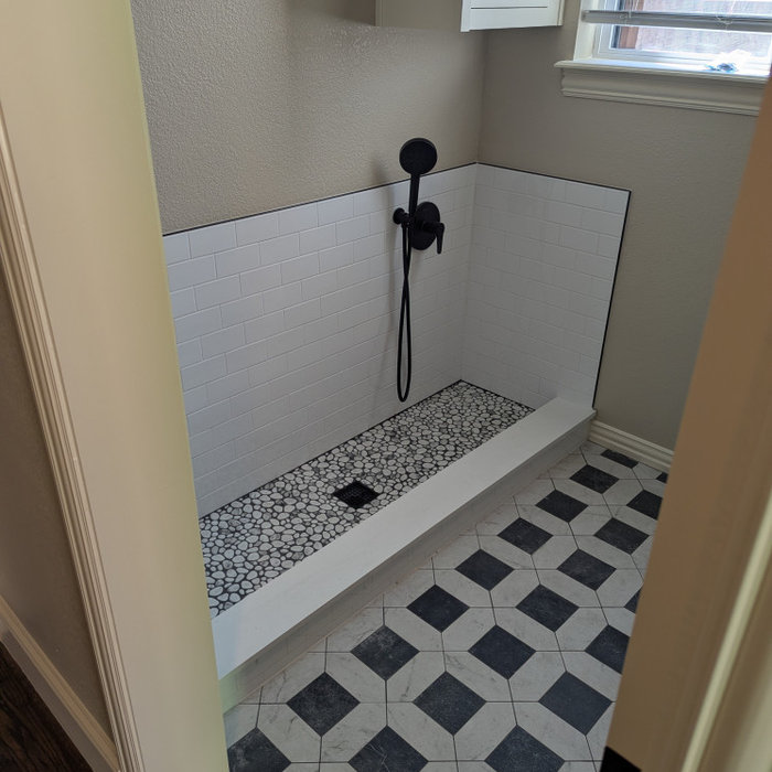 AFTER, (almost) check out the beautiful tile work! Subway tile for the backsplash, stonework for the puppy's pads and classic tile for the rest of the laundry room.