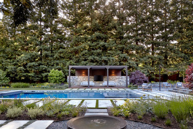Expansive contemporary backyard rectangular lap pool in San Francisco with a hot tub and natural stone pavers.