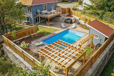 Design ideas for a huge contemporary full sun backyard concrete paver retaining wall landscape in Other for summer.