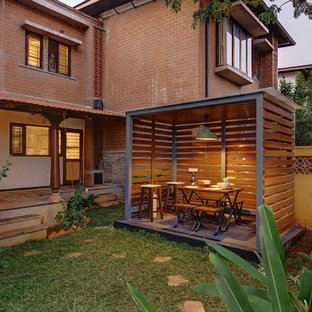 Idées déco pour un jardin avec une terrasse en bois ou composite arrière exotique.