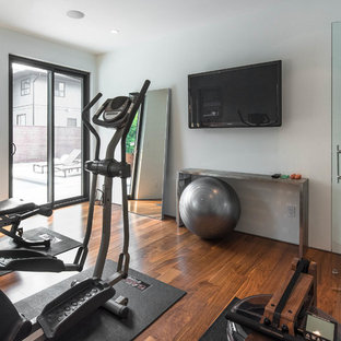 バンクーバーの小さいミッドセンチュリースタイルのおしゃれなホームジム (白い壁、無垢フローリング、茶色い床) の写真