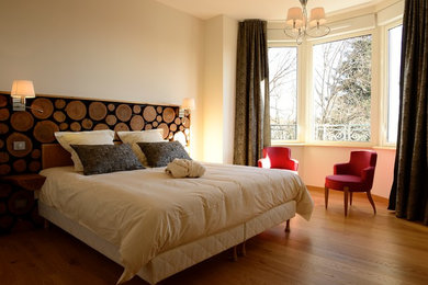 Design ideas for a large modern master bedroom in Saint-Etienne with white walls and medium hardwood floors.