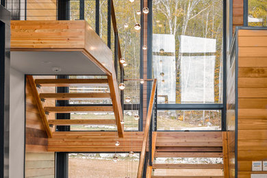 Inspiration for a large country wood u-shaped staircase in Boston with open risers and cable railing.