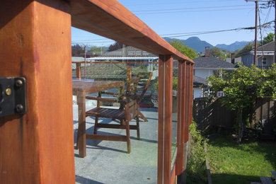 Example of a mid-sized trendy backyard deck design in Vancouver with no cover
