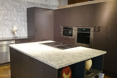 Inspiration for a mid-sized transitional l-shaped concrete floor and brown floor enclosed kitchen remodel in Hawaii with an island, flat-panel cabinets, gray cabinets, quartz countertops, white backsplash, porcelain backsplash and stainless steel appliances