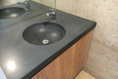 Design ideas for a contemporary bathroom in Melbourne with flat-panel cabinets, medium wood cabinets, concrete floors, an integrated sink and concrete benchtops.