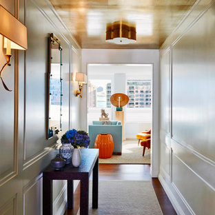 ニューヨークの中サイズの片開きドアトランジショナルスタイルのおしゃれな玄関ホール (白い壁、茶色い床、濃色無垢フローリング) の写真