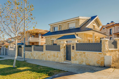 Foto de fachada de casa beige y negra de estilo de casa de campo de tamaño medio de dos plantas con revestimiento de piedra, techo de mariposa y tejado de teja de barro